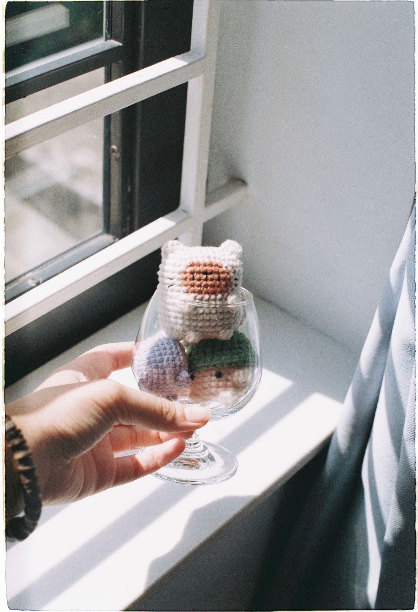 Small crocheted amigurumi animals held in a hand